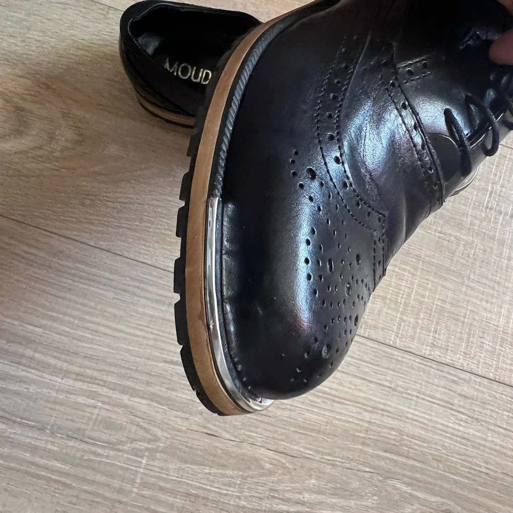 Men’s black leather wingtip shoes. Silver band at toe. Size 8 1/2